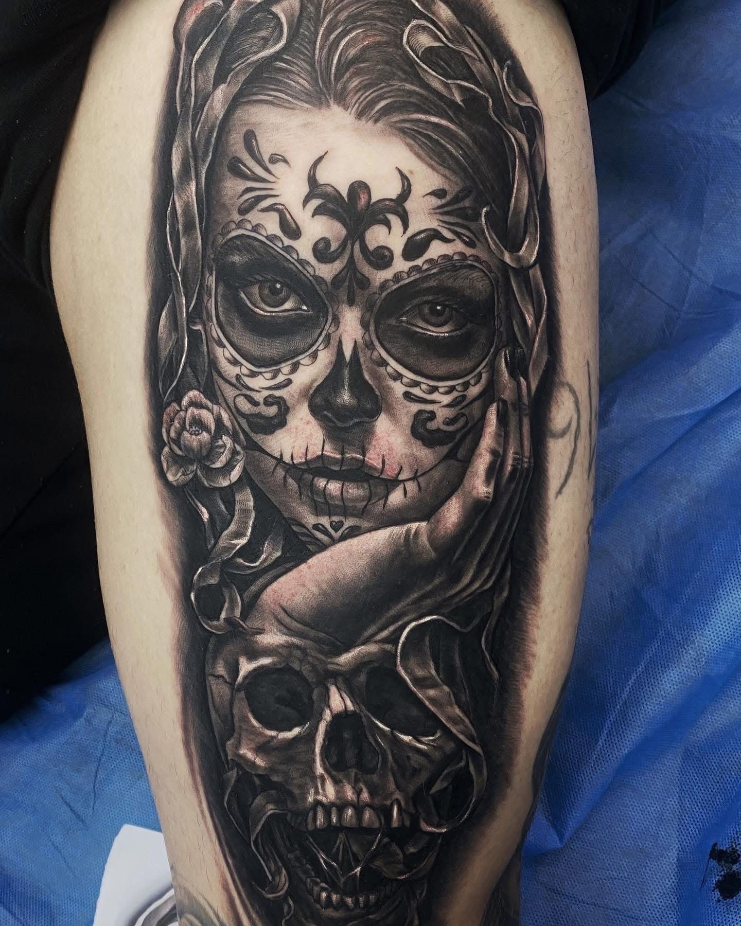 Tattoo of a woman's face decorated as a sugar skull, with a lower skull and hand detail, in grayscale. — Whitsunday Tattooing Airlie Beach in Whitsundays, QLD