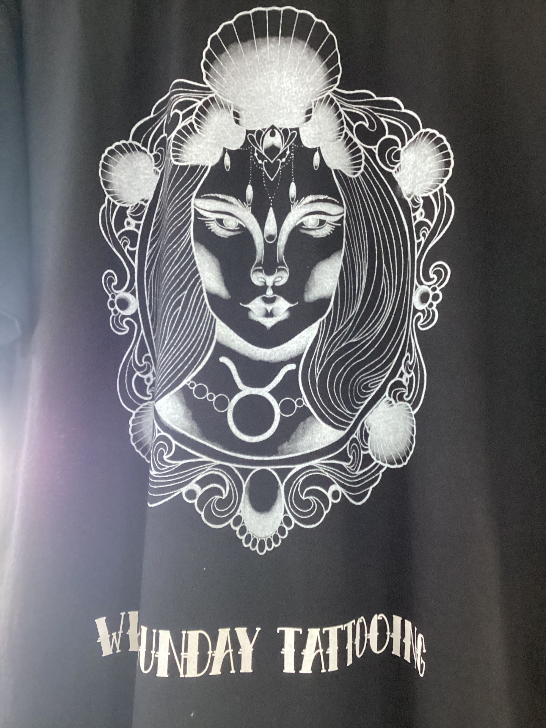 A Silver Illustration of A Woman's Face Within a Seashell — Whitsunday Tattooing Airlie Beach in Airlie Beach, QLD