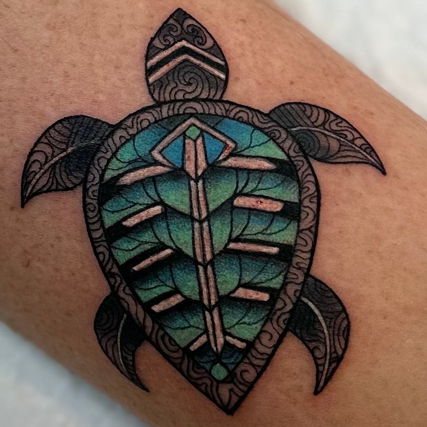 Turtle tattoo, teal and green shell with black outline on skin.