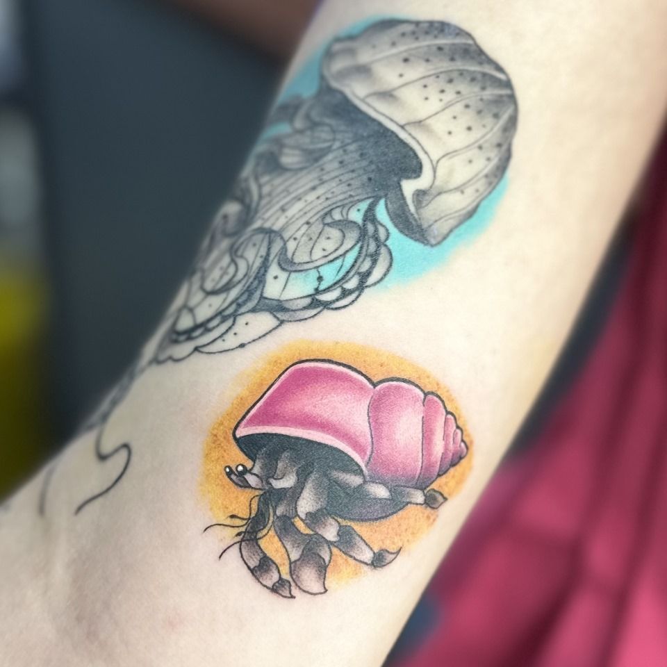 Tattoo of a black and white jellyfish above a colorful hermit crab. — Whitsunday Tattooing Airlie Beach in Whitsundays, QLD
