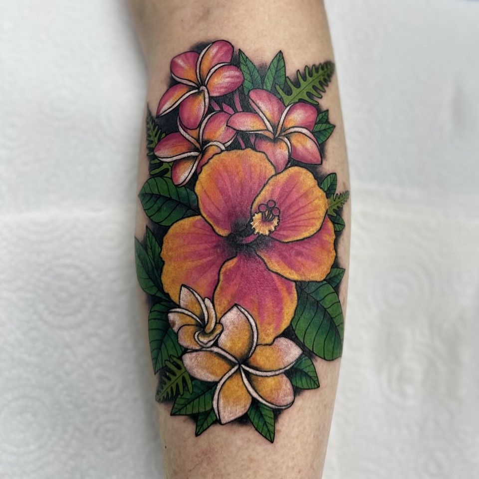 Tattoo of orange and pink flowers, surrounded by green leaves, on pale skin. — Whitsunday Tattooing Airlie Beach in Whitsundays, QLD