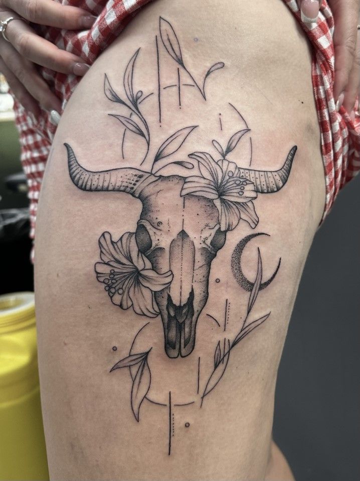 Tattoo on a thigh: bull skull with flowers and geometric elements in black ink. — Whitsunday Tattooing Airlie Beach in Whitsundays, QLD
