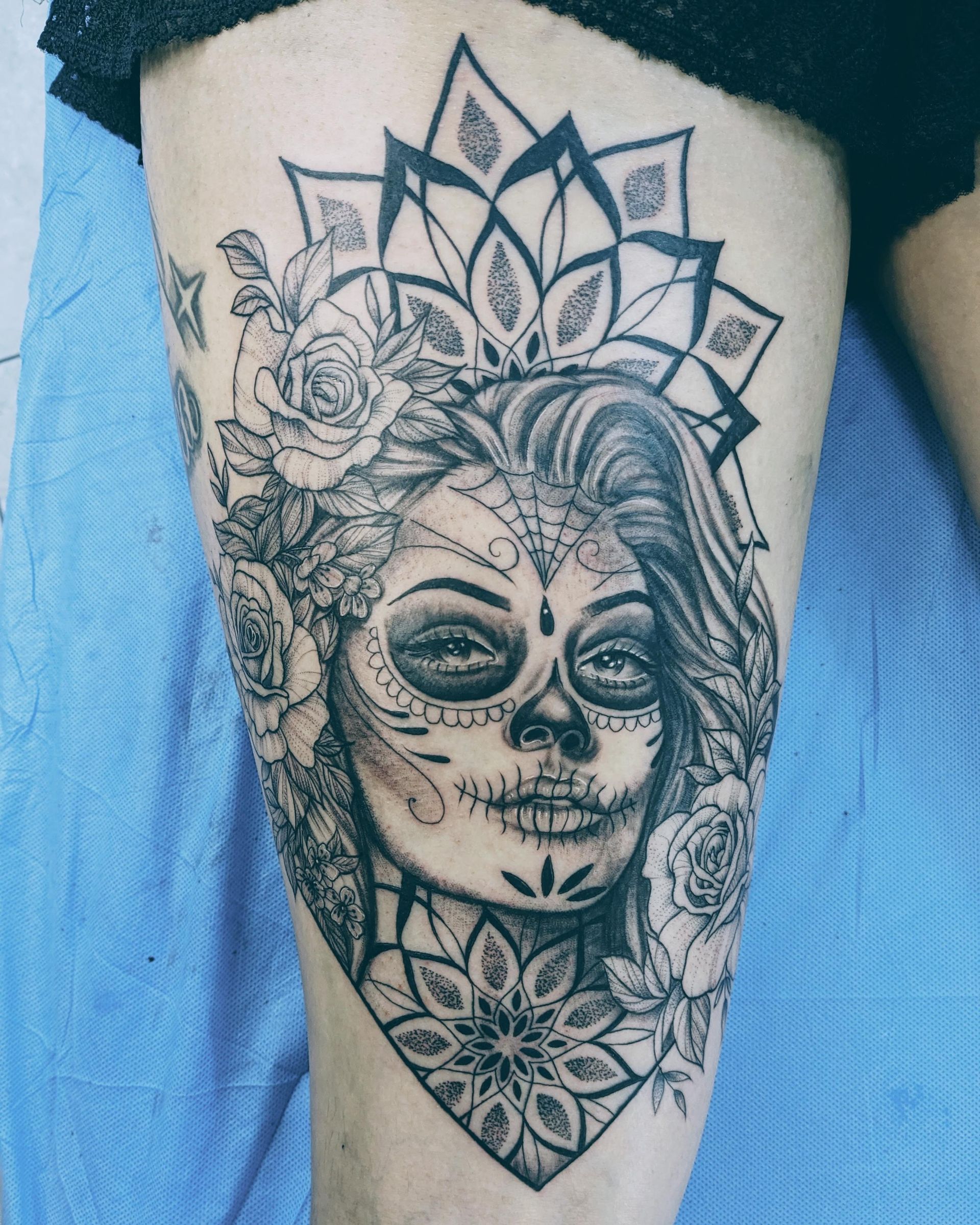 Tattoo on thigh: Sugar skull woman with floral crown and mandala designs.