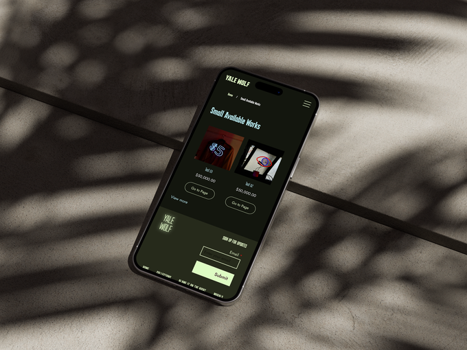 Laptop displaying Emily Wise website on a stone block, purple background.