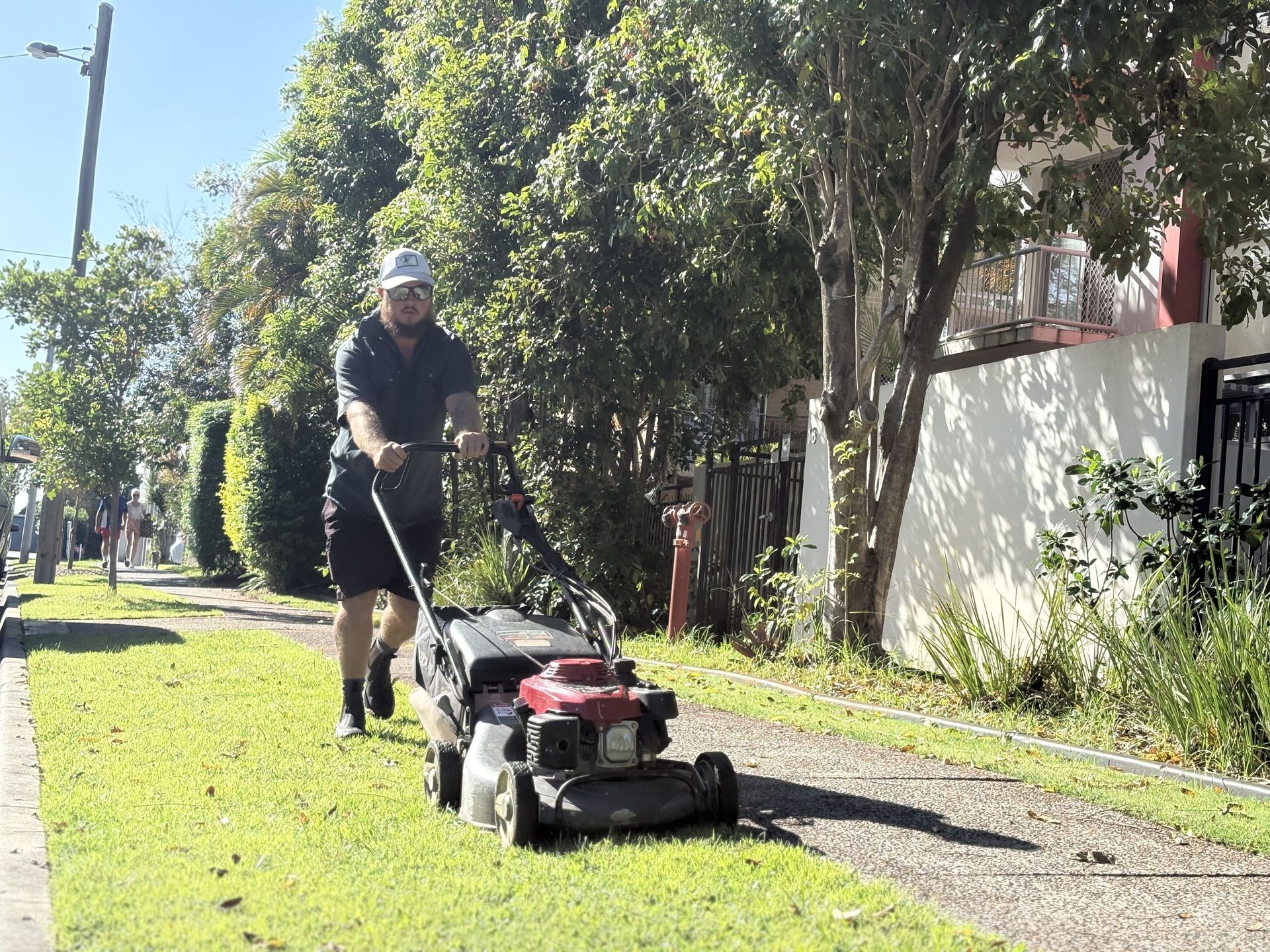 A man is mowing his lawn with a lawn mower | MowAbility Garden Services Gold Coast