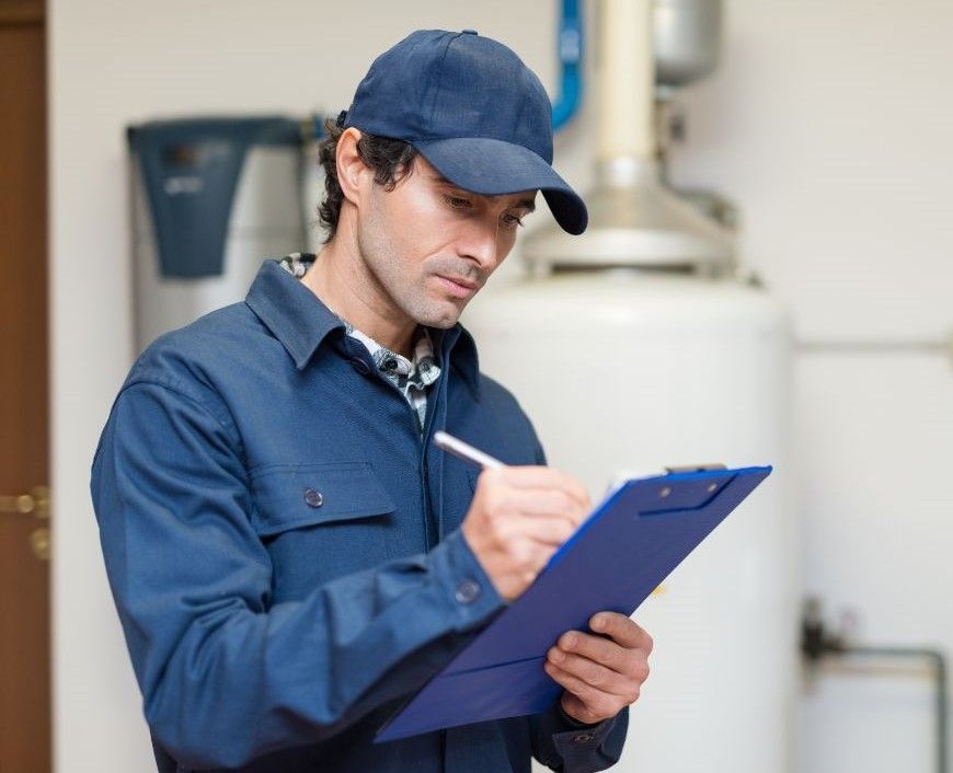 A man is sitting on the floor fixing an air conditioner.