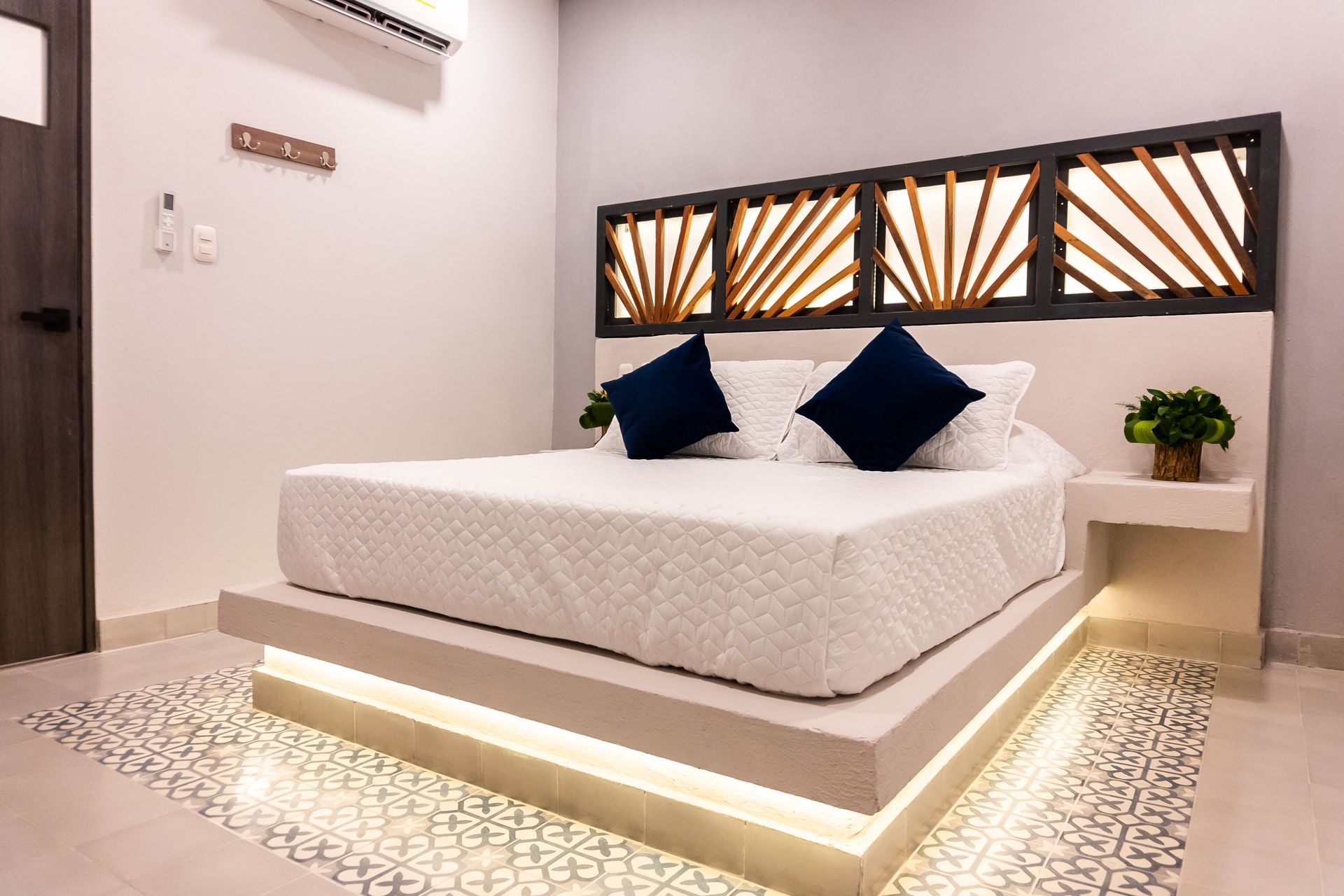 Dormitorio con cama blanca, lámparas colgantes de mimbre, puertas abiertas al exterior, ventilador de techo.