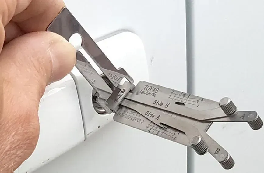Hand Holding a Car Door Lock Pick Tool — Nq Locksmiths in Ingham, QLD