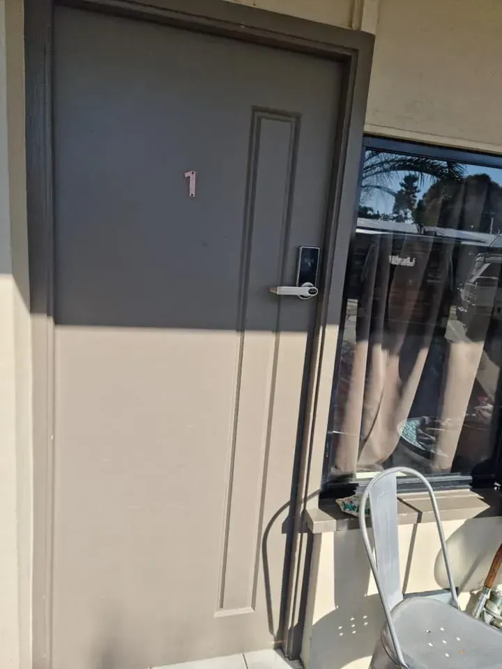A Door with Number 1, Next to A Window with A Chair — Nq Locksmiths In Kirwan, QLD