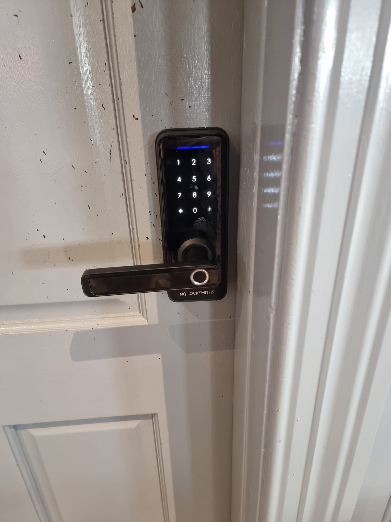 Black Smart Lock with Keypad and Fingerprint Scanner on A White Door — Nq Locksmiths In Kirwan, QLD