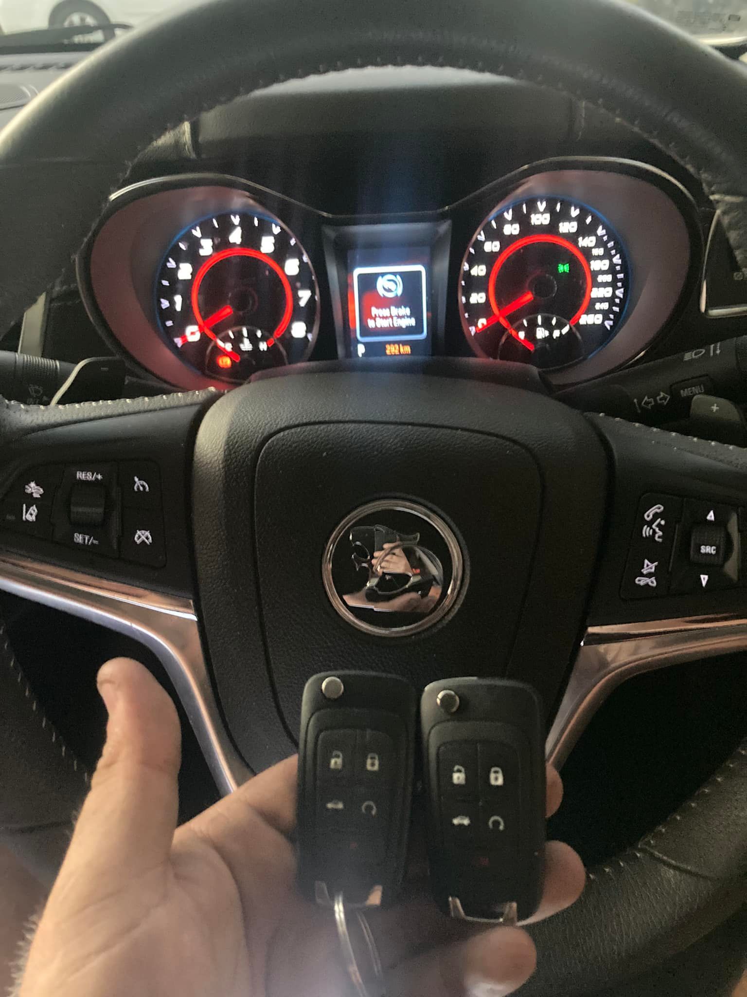 Two Black Car Keys, One Rectangular with Three Buttons, One Rounded with Two Buttons, in A Plastic Organizer — Nq Locksmiths In Kirwan, QLD