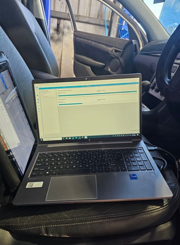 Man in Yellow Shirt and Ear Protection Uses a Tool Near a Wall in An Office Setting — Nq Locksmiths In Kirwan, QLD