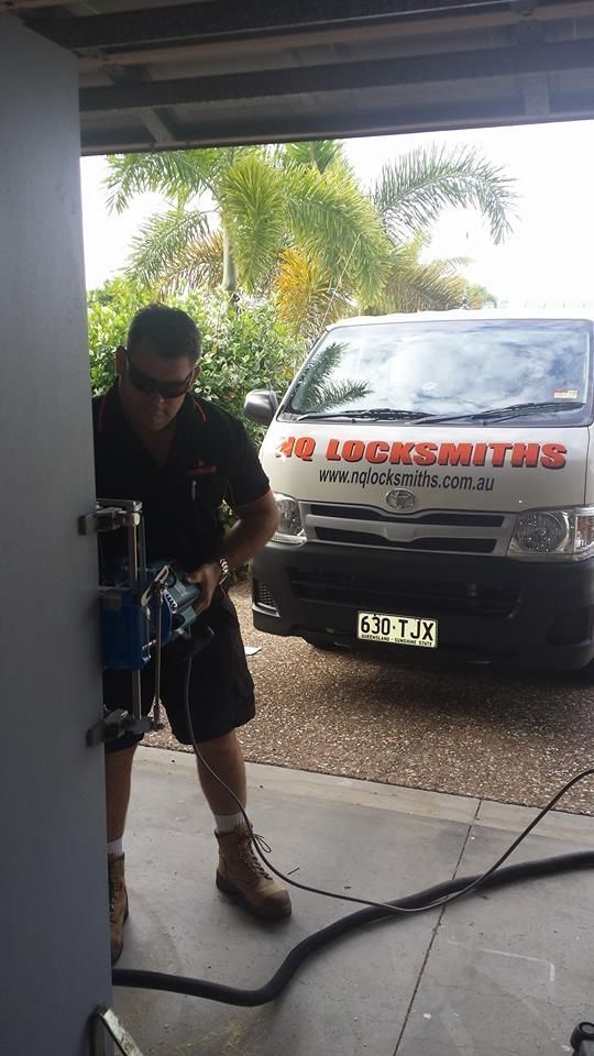 Locksmith Drilling a Door, Van Logo Visible — Nq Locksmiths In Kirwan, QLD