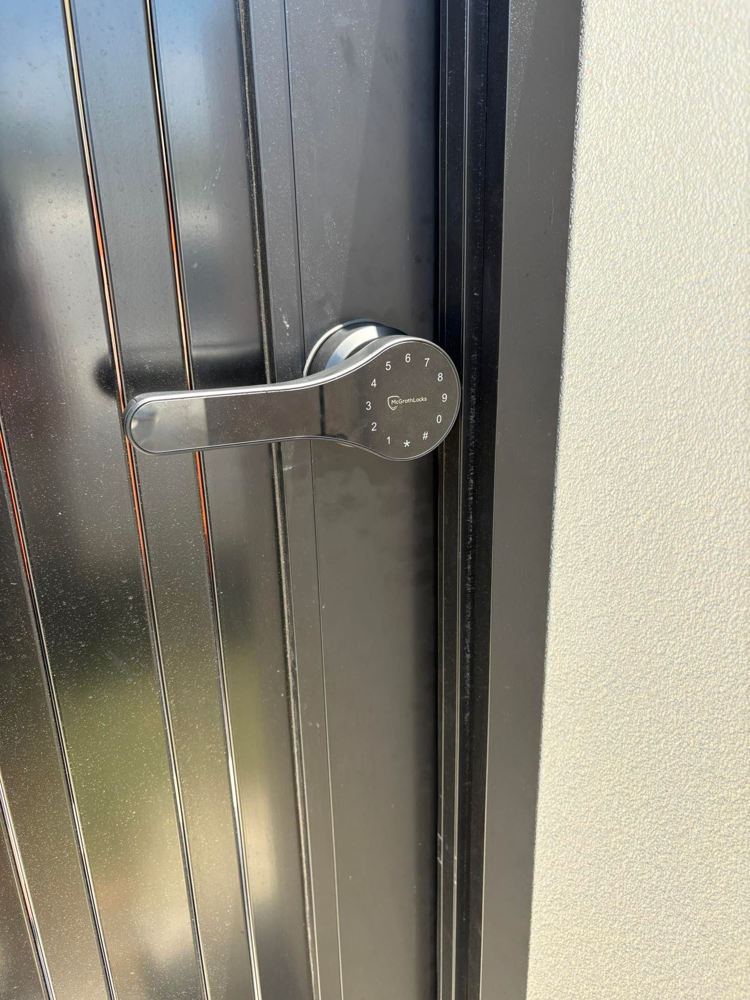Black Metal Door with A Modern Handle and Lock Mechanism — Nq Locksmiths in Charters Towers, QLD