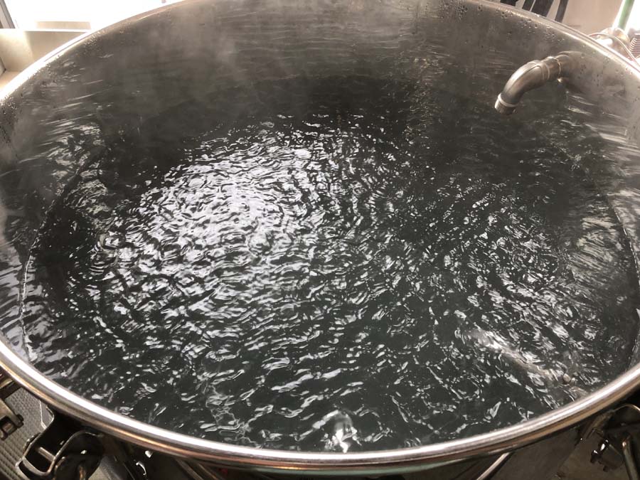 A large pot of water is boiling on a stove.