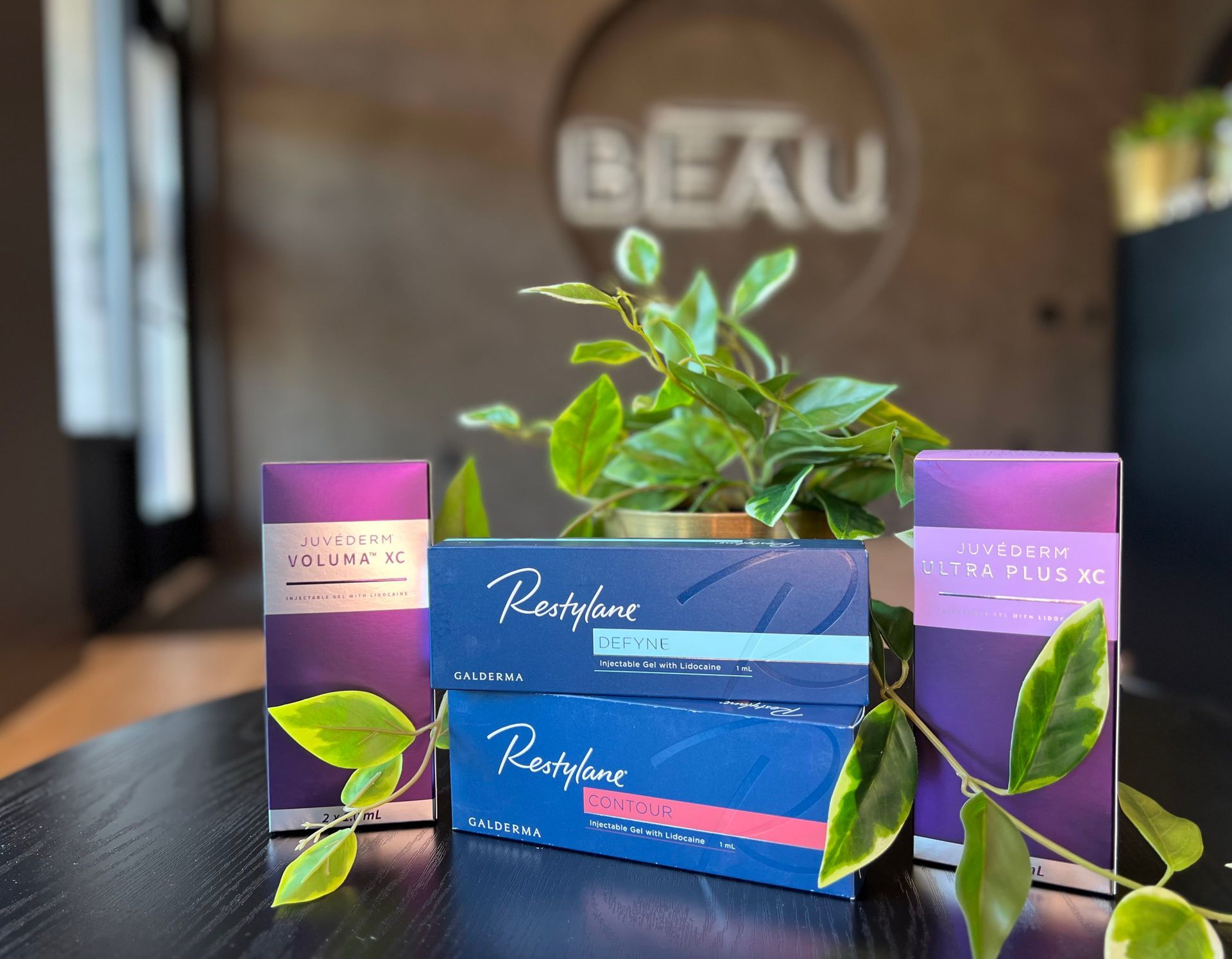 Boxes of Restylane filler products on a table with a plant, the word 