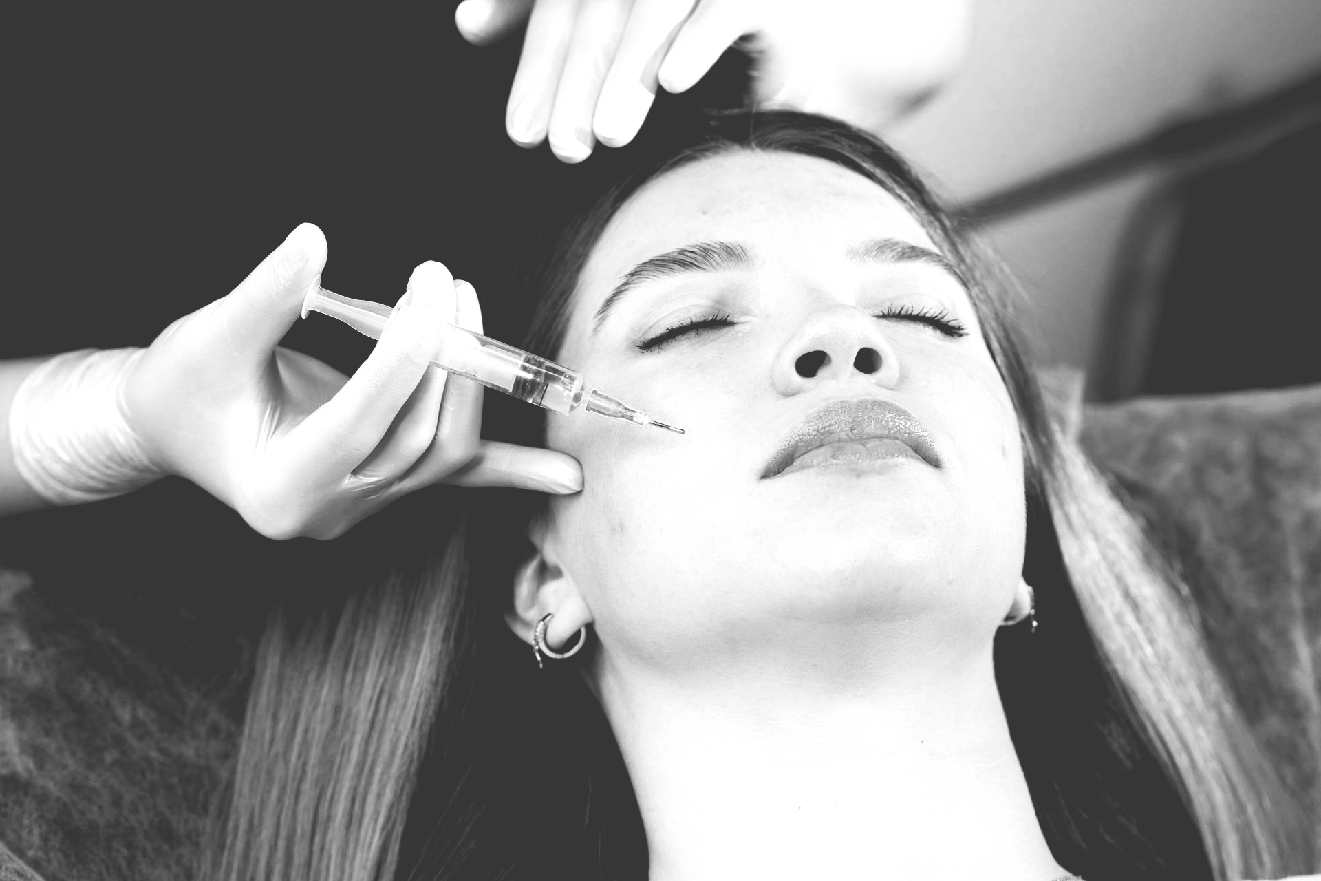 A woman is getting a botox injection in her face.
