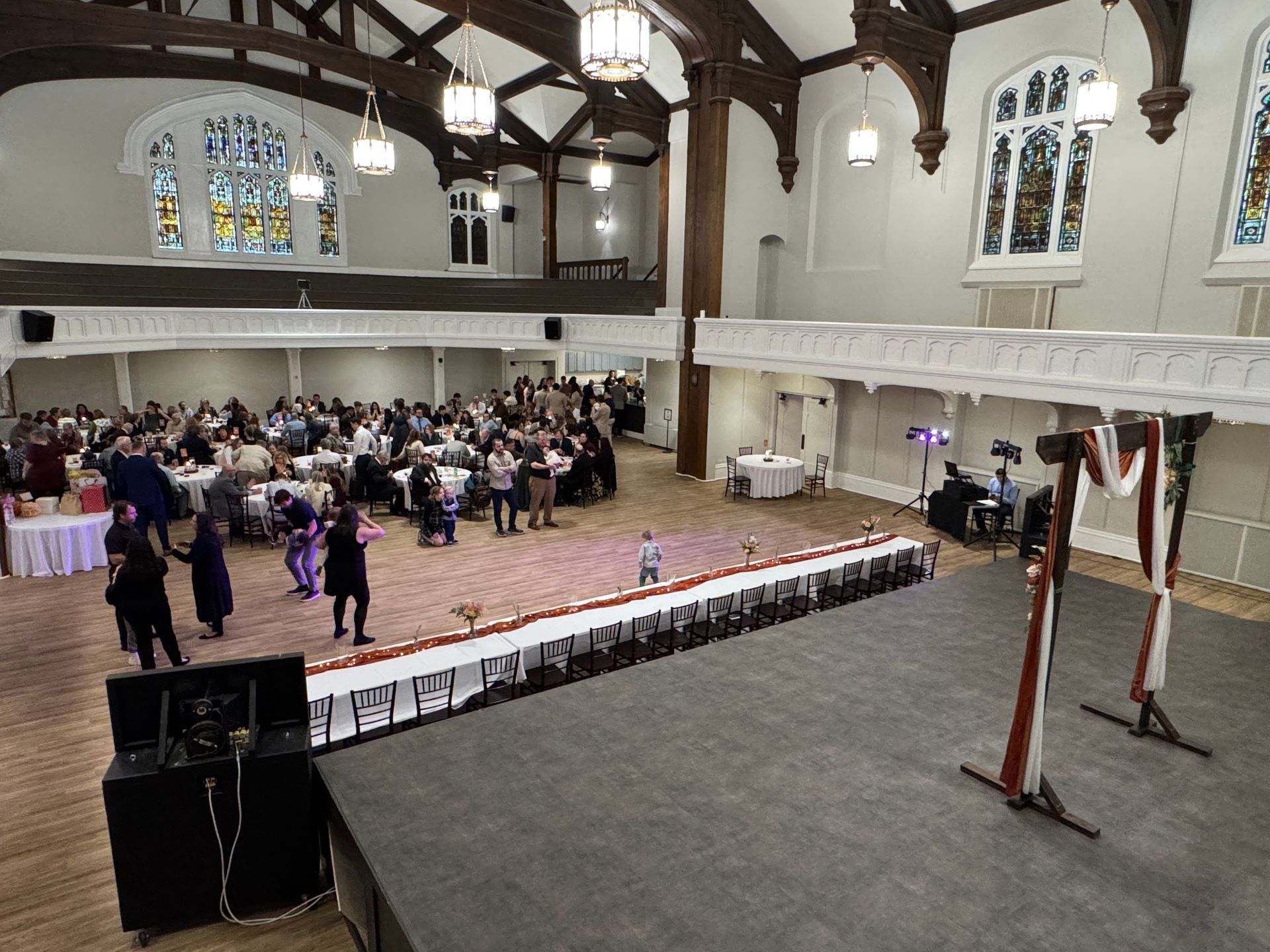 A large room with a stage and people dancing on it.