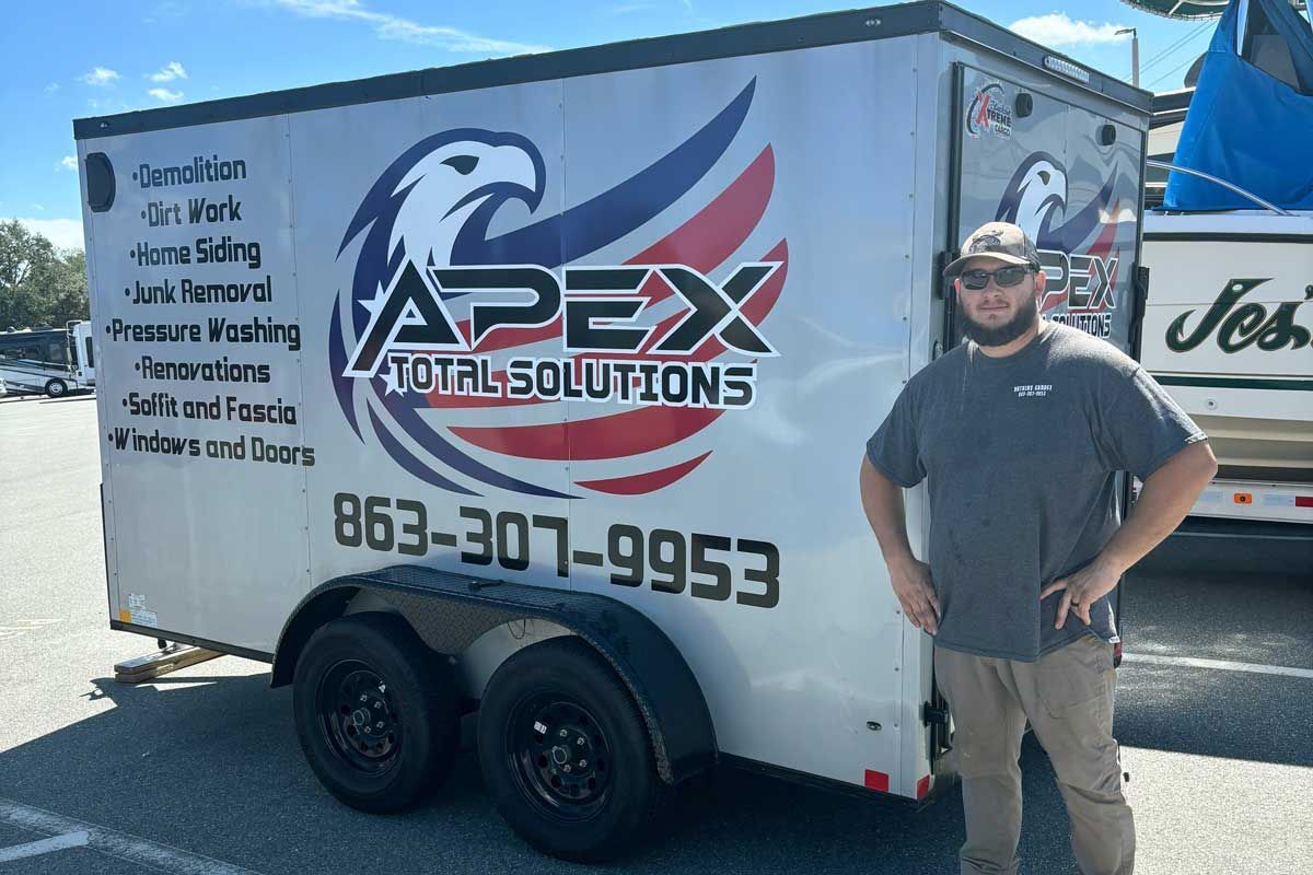 Man stands in front of a trailer with company logo 