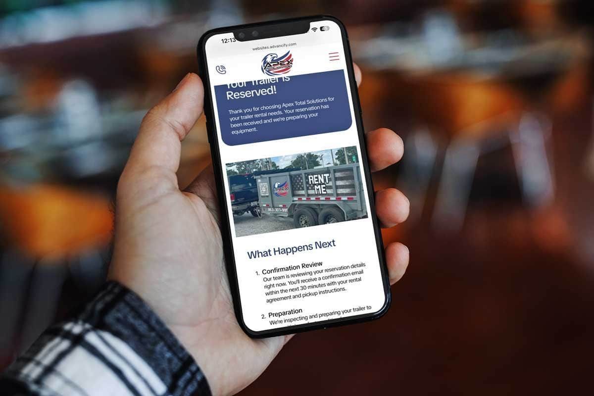 Hand holding a smartphone displaying a webpage about a towing company with a photo of a tow truck.