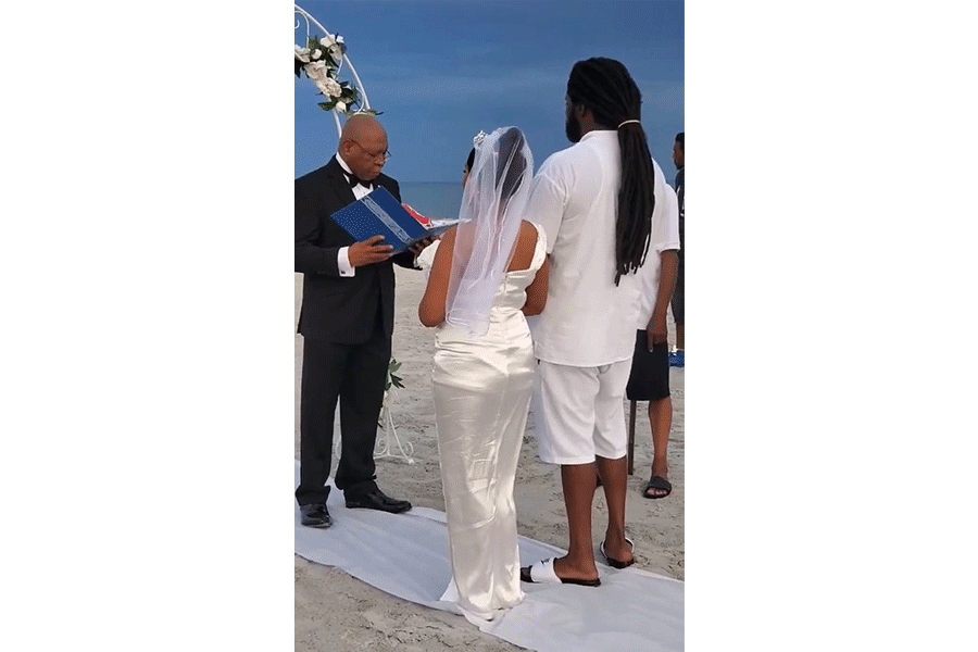A bride and groom are getting married on the beach.