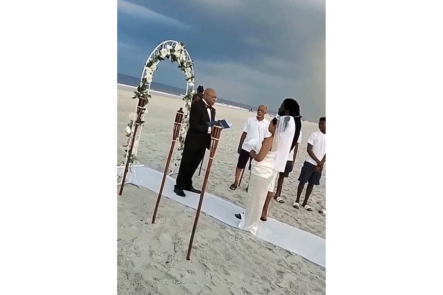 A bride and groom are getting married on the beach.