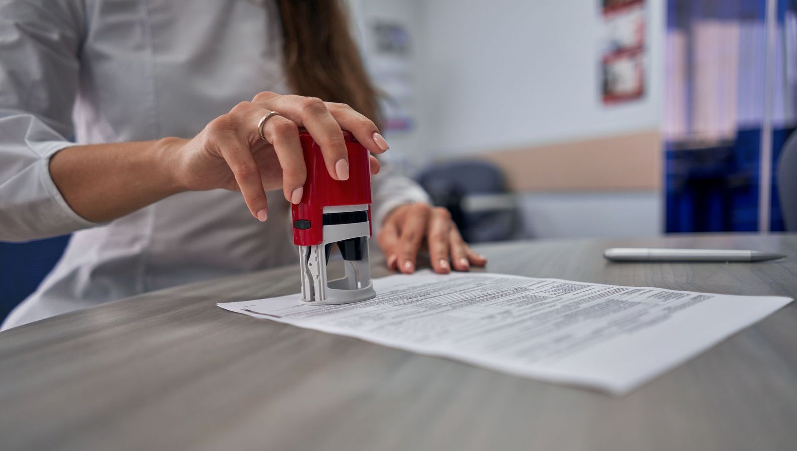 A person is stamping a document on a laptop.