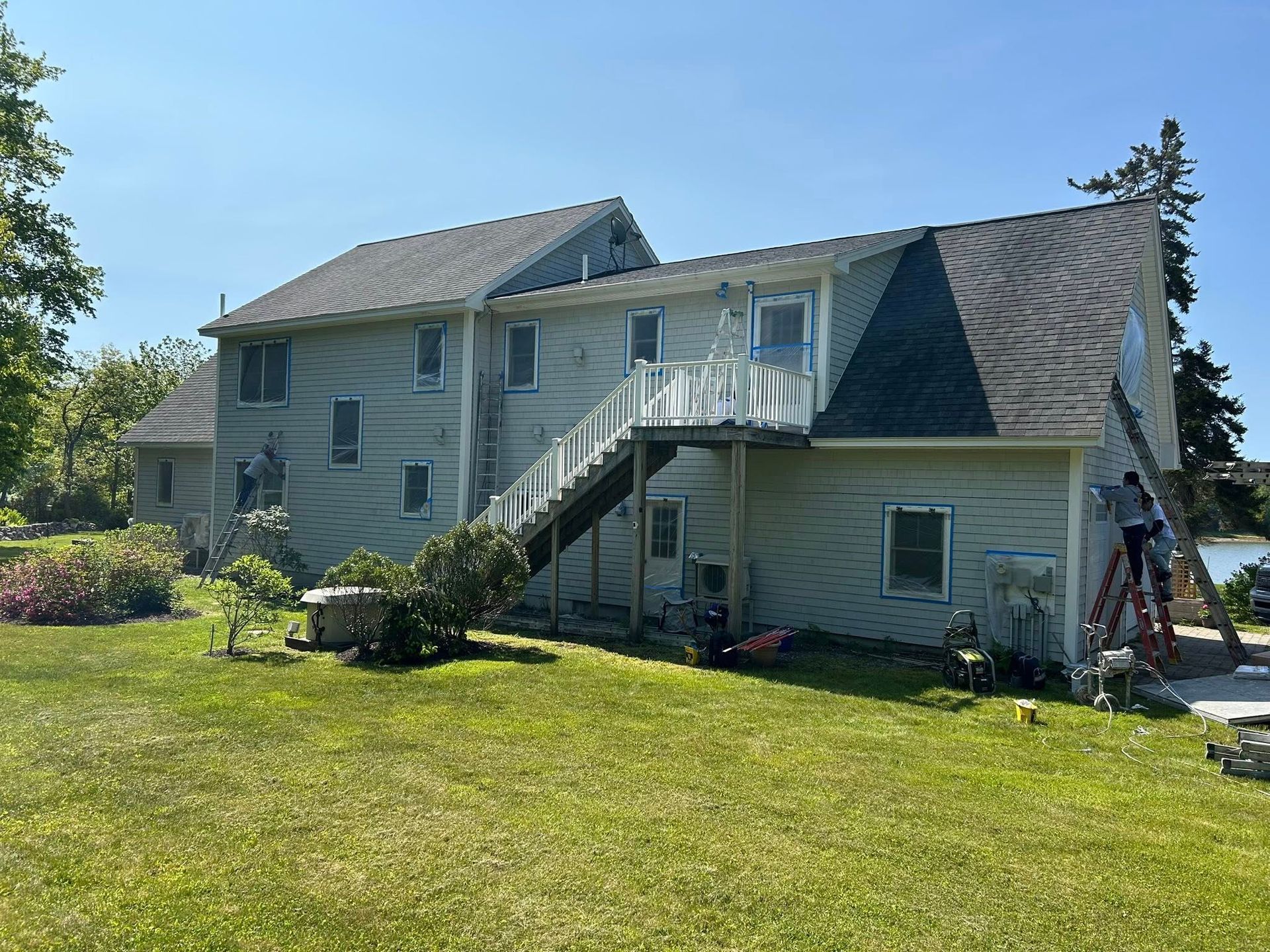 A group of people are painting a large house.