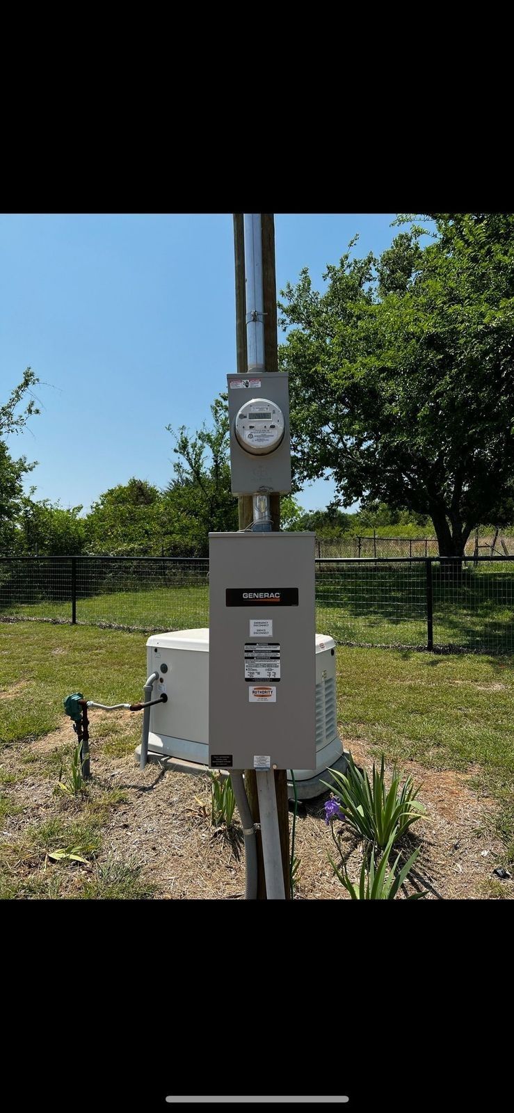 A meter is sitting on top of a pole in a field.