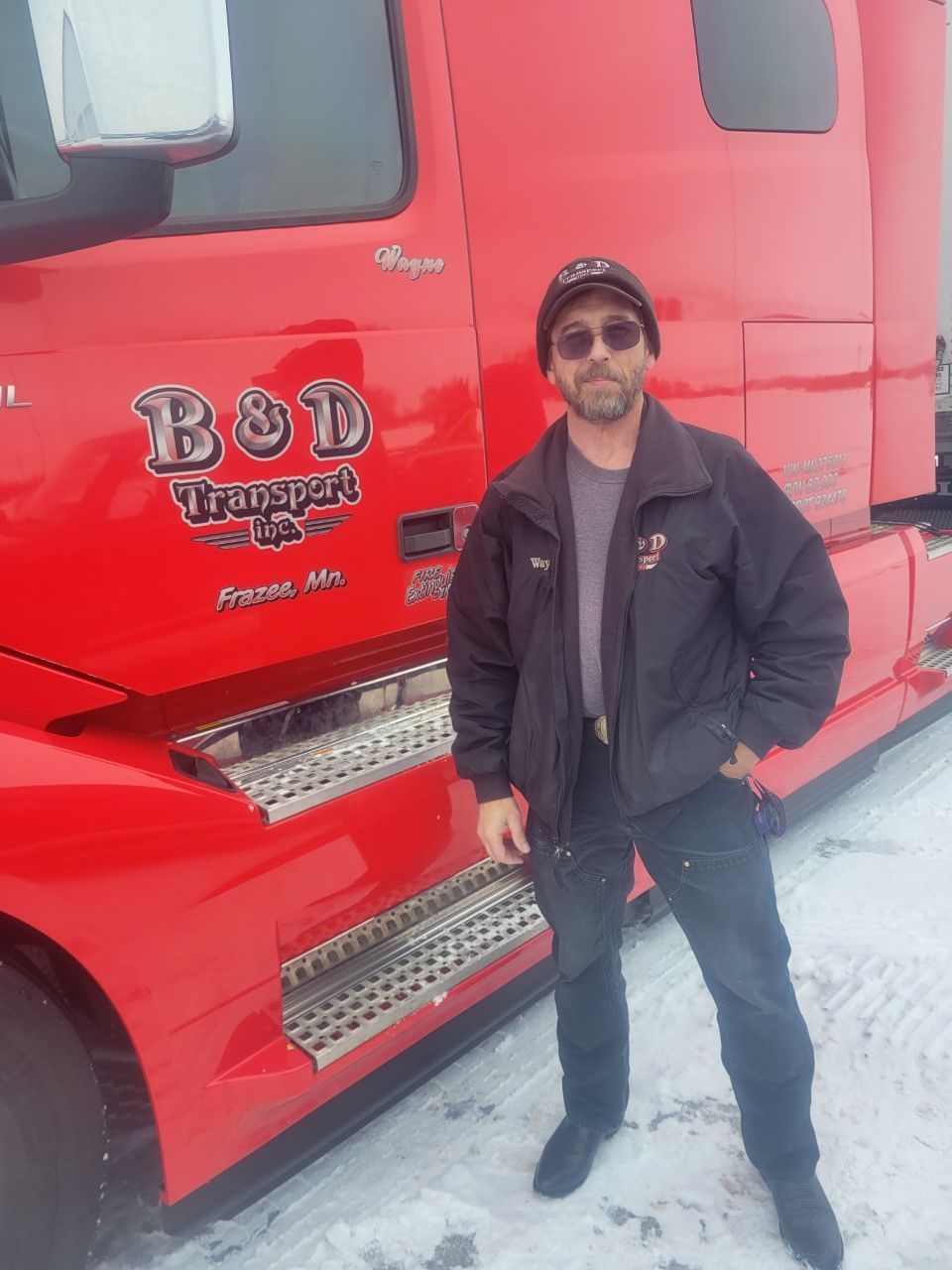 A man standing in front of a red truck that says bod