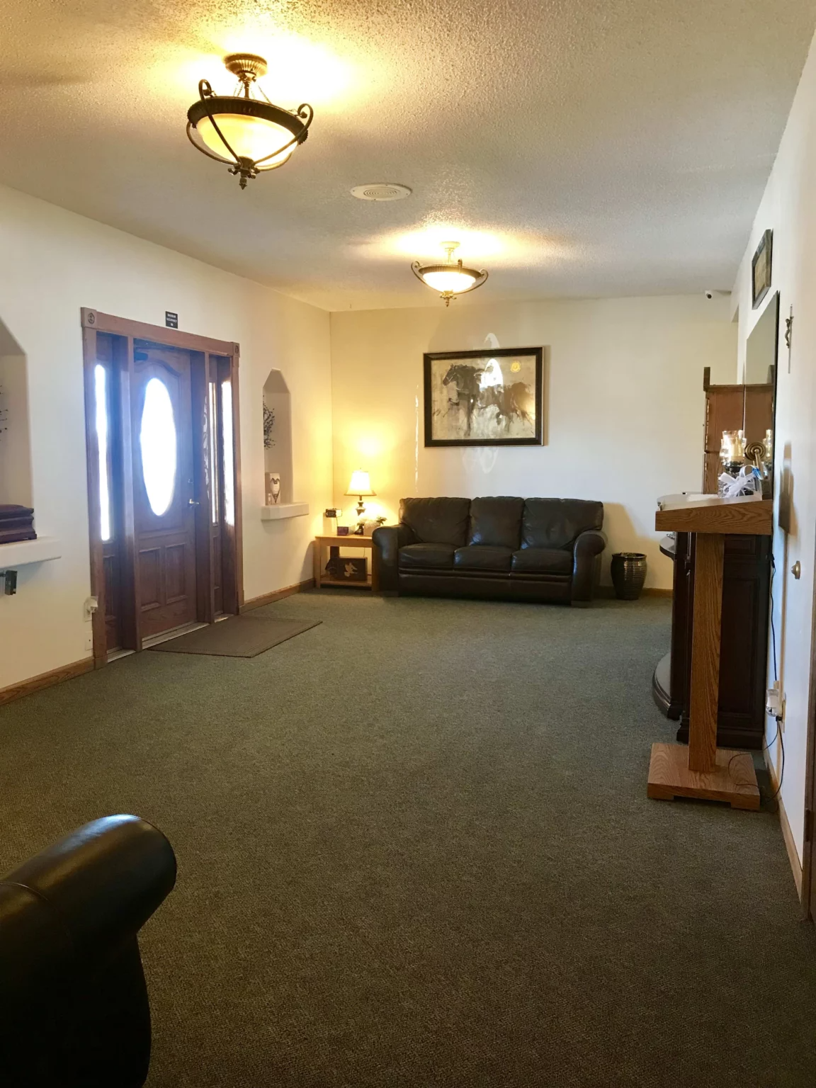 A living room with a couch , chairs , and a door.