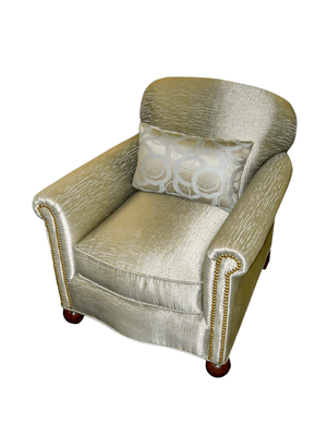 Tan upholstered armchair with a decorative pillow.