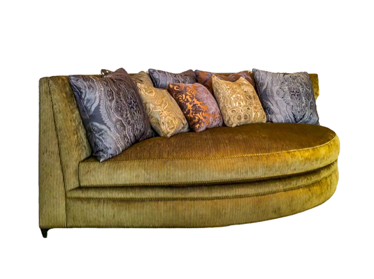 Curved gold sofa with patterned throw pillows.
