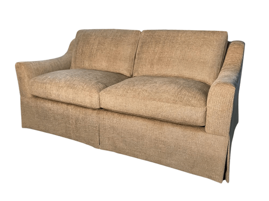 Beige two-cushion sofa with skirted base and slightly curved arms.
