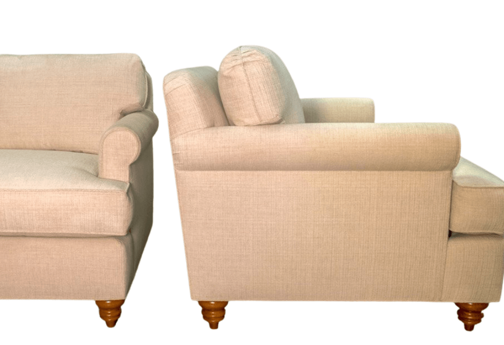 Beige upholstered armchair with rolled arms and wooden legs.