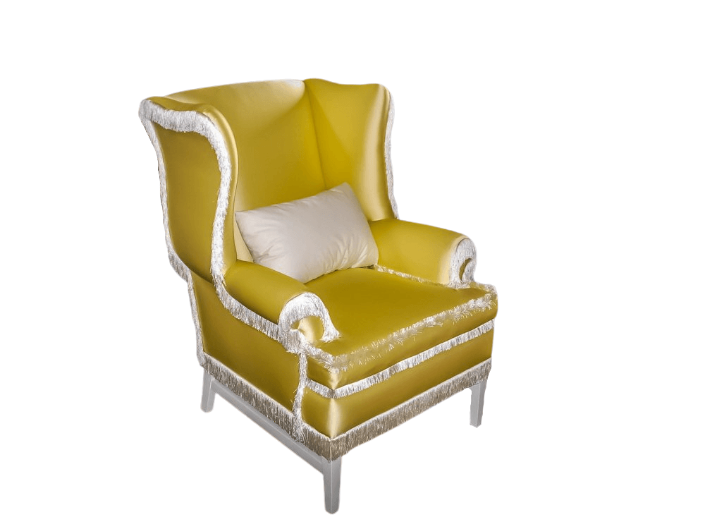 Yellow upholstered armchair with white fringe and pillow.