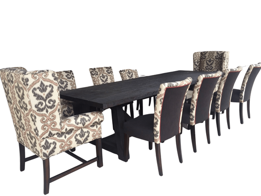 Dining room set with a long, dark wooden table and patterned chairs.