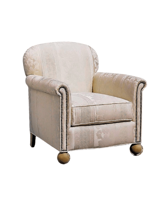 Cream-colored armchair with rolled arms, patterned upholstery, nailhead trim, and round wooden feet.