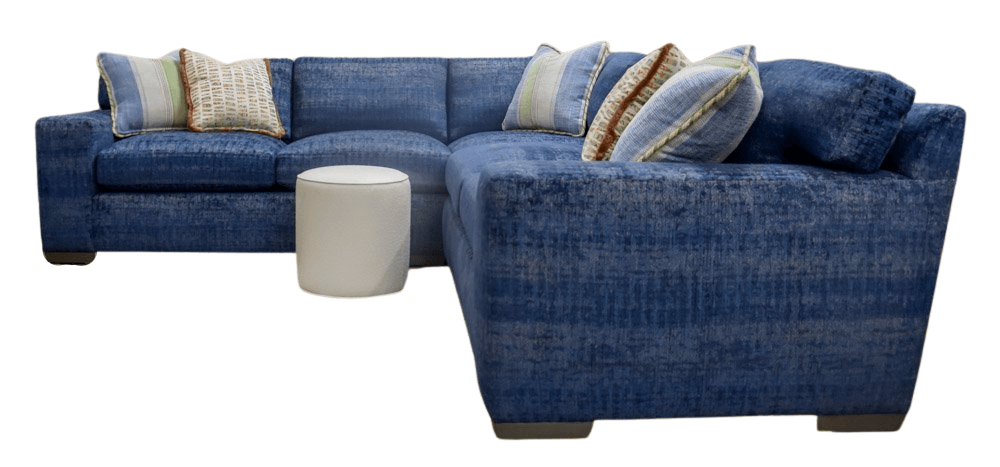 Blue sectional sofa with decorative pillows and an off-white ottoman.