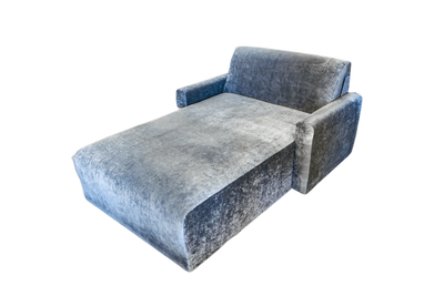 Gray velvet chaise lounge with a squared back and armrest.