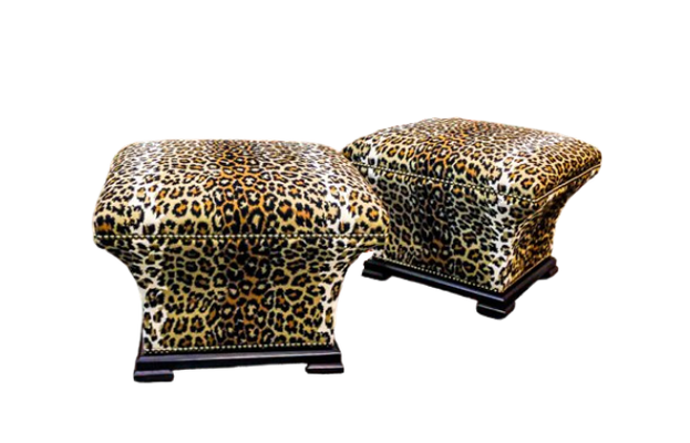 Two leopard-print upholstered ottomans on a white background.