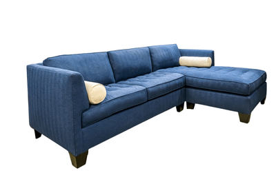 Blue sectional sofa with two bolster pillows, isolated on white.