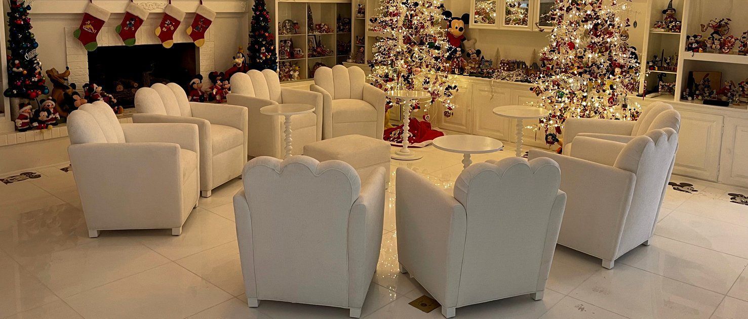 White chairs arranged around a table in a Christmas-decorated room.