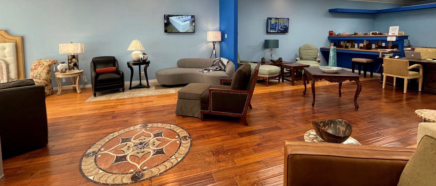 A furniture store interior with hardwood floors, blue walls, and various displayed items.