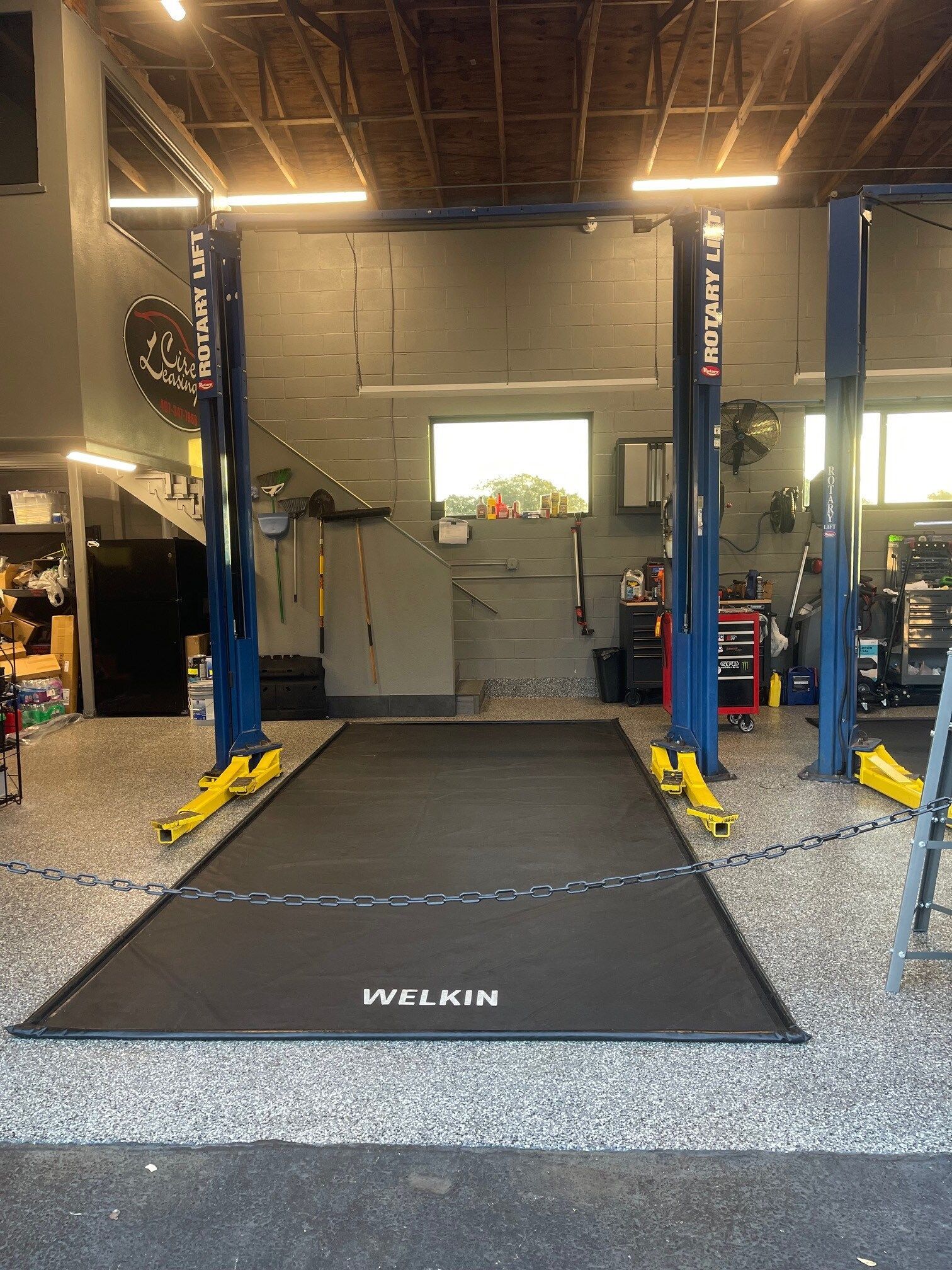 Shop's interior with a floor lift, tools, and equipment | High Line Service & Repair