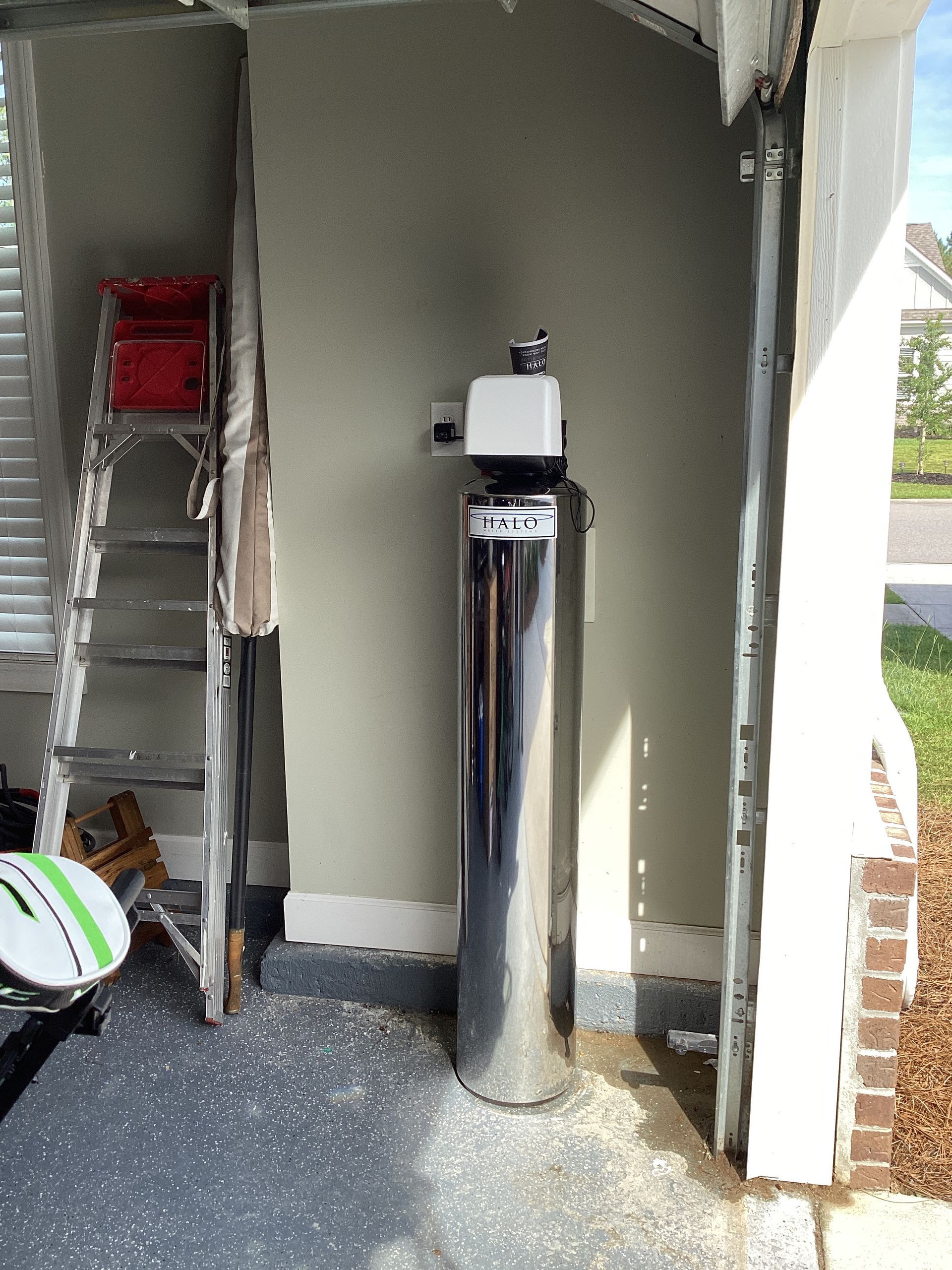 Under-sink water filtration system with tanks, filters, and plumbing in a cabinet
