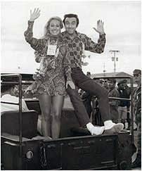 A man and a woman are sitting in the back of a truck.
