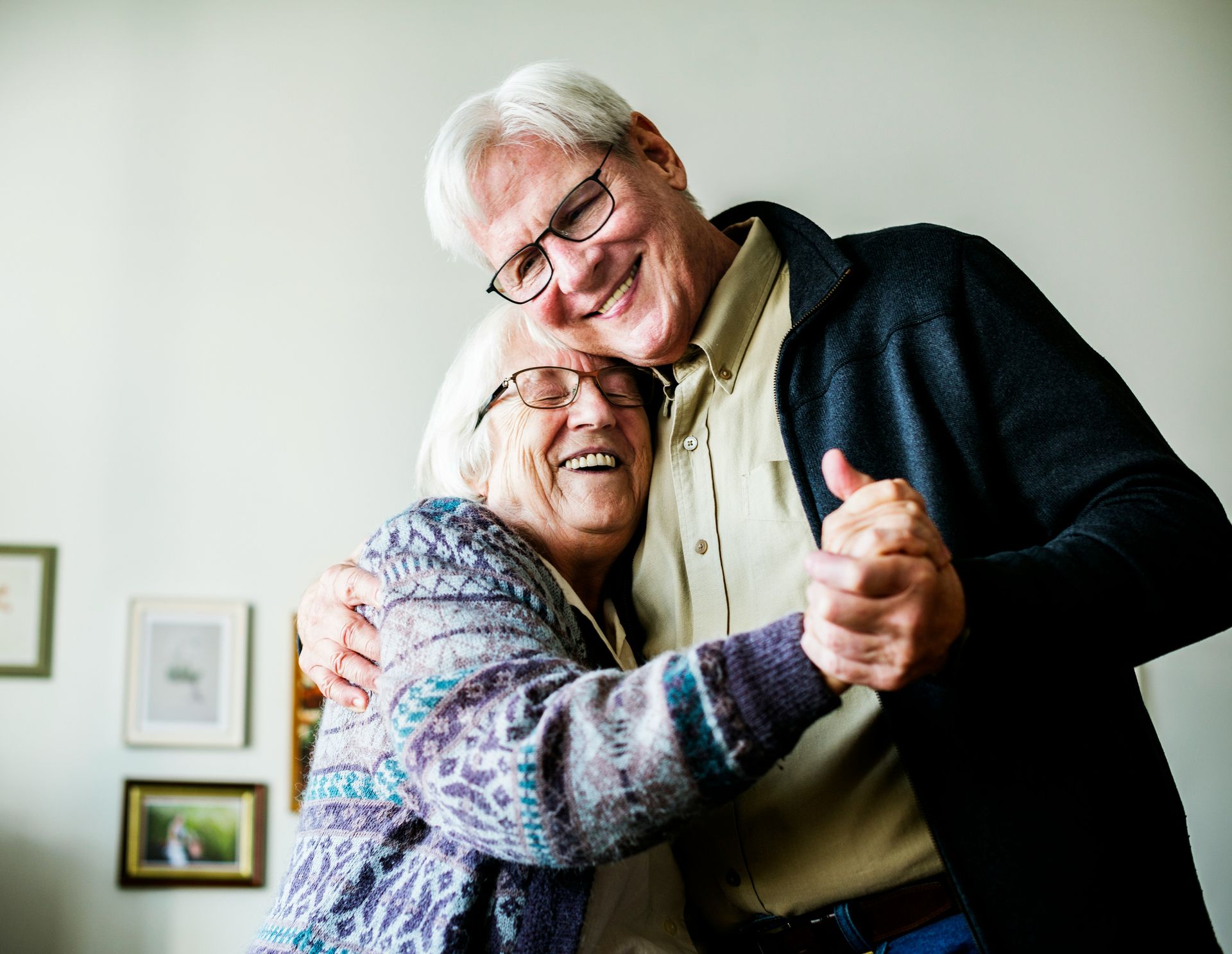 Elderly couple dancing closely, smiling warmly.