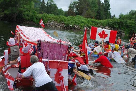 A group of people in boats with canadian flags on them