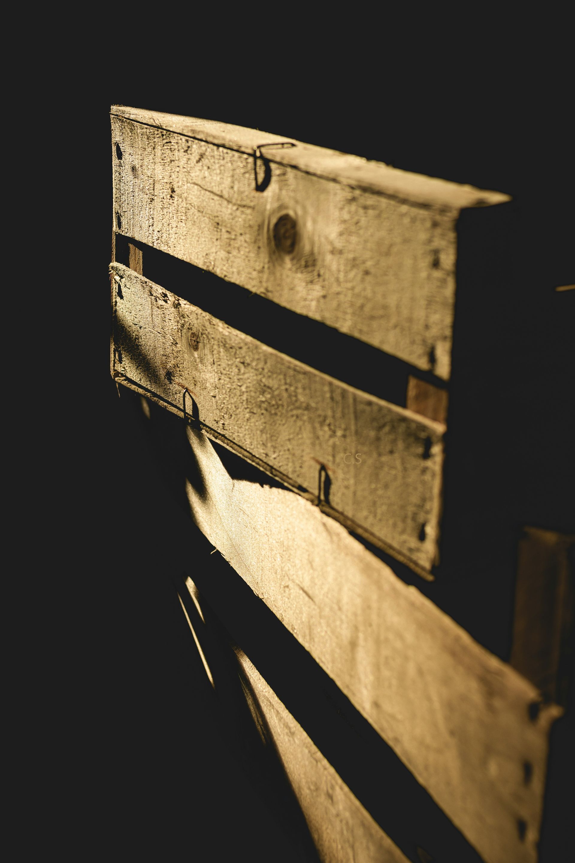 A close up of a wooden box with a black background